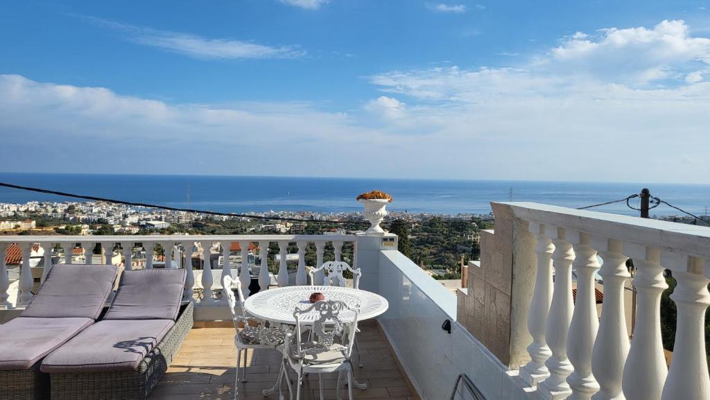 balkon ze stołem i krzesłami oraz oceanem w obiekcie Room in Apartment - Spacious Room in Creta for 3 people, with Ac, Swimming Pool and Nature w mieście Hersonissos