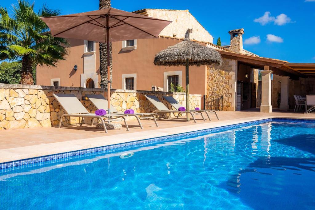 una villa con piscina di fronte a una casa di Villa Cas Cuni a Felanitx