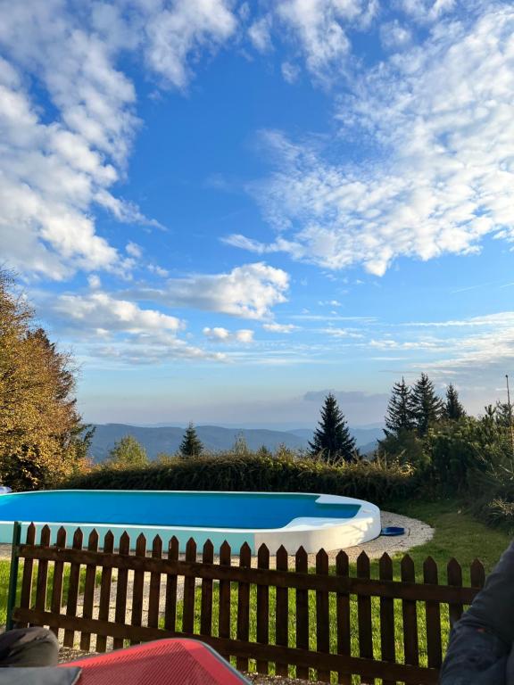 a swimming pool in a yard with a wooden fence at Penzion Patrik Mikulčin vrch in Vápenice