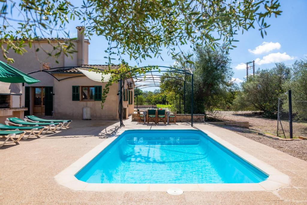 una piscina en un patio con sillas y una casa en Sa Torreta en Algaida