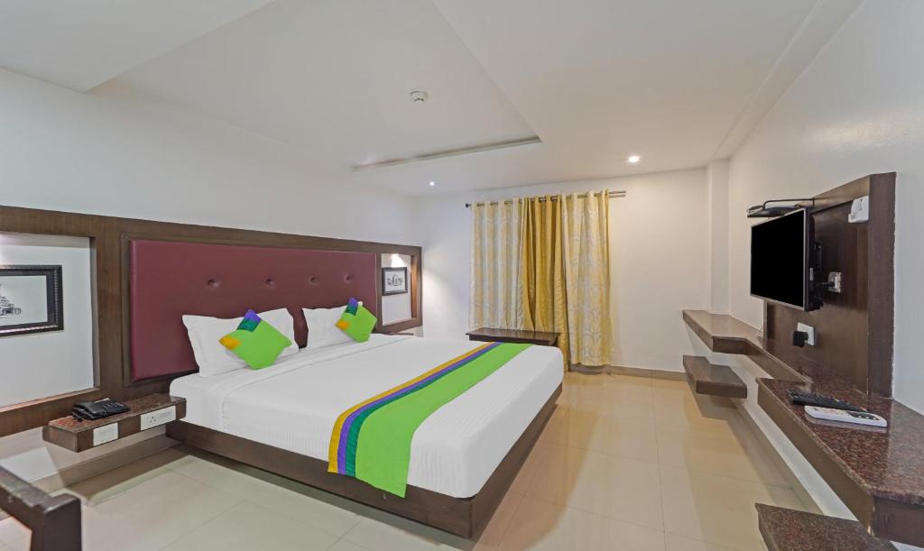 a hotel room with a bed and a tv at Treebo Trend South Avenue 4 Min Walk From Promenade Beach in Pondicherry