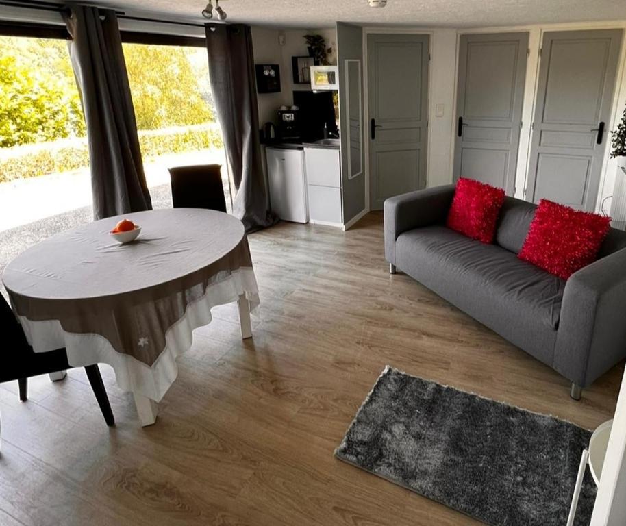 sala de estar con sofá y mesa en Chambres d'hôtes Elcy, 