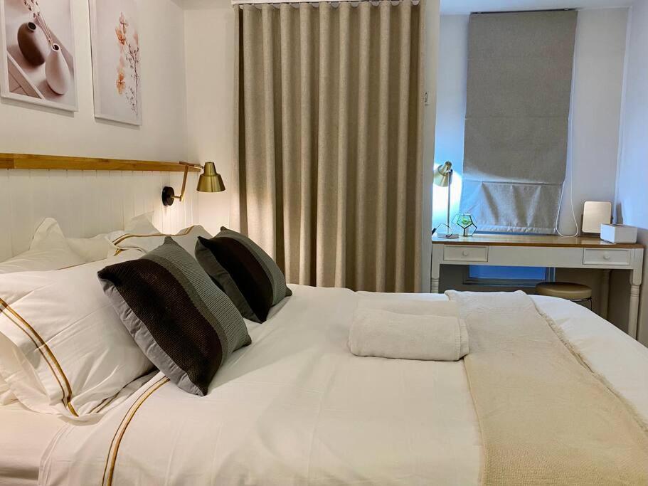 uma grande cama branca num quarto com uma janela em Camaya at tanglin apartement em Lontar