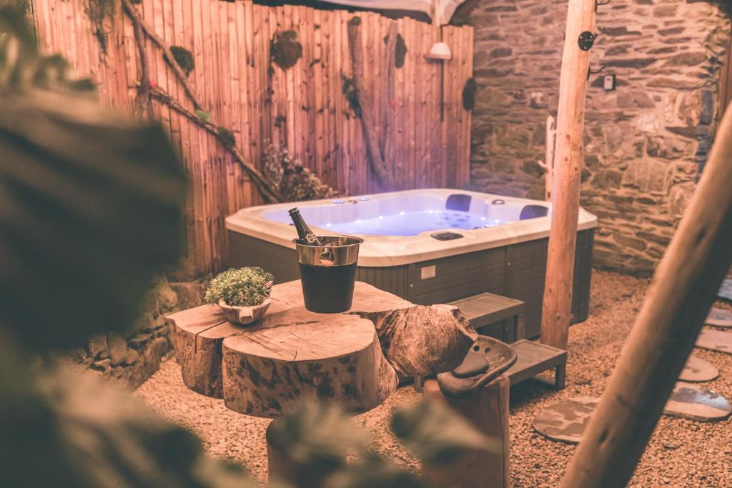 ストゥモンにあるRomantic Getaway - Sauna and Jacuzzi - El Clandestinoのバスタブ、テーブルに座ったワイン1本