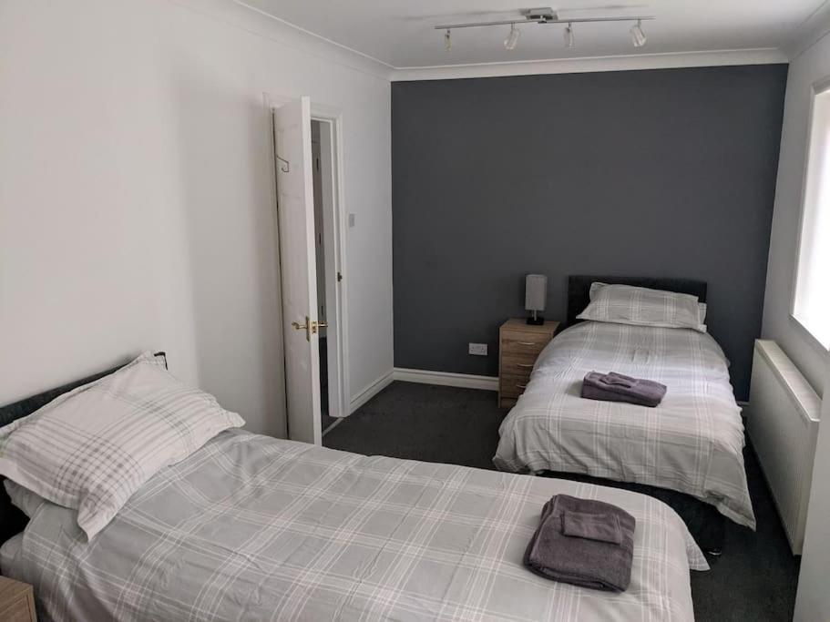 a bedroom with two beds with towels on it at Teith court apartment with private parking. in Stirling