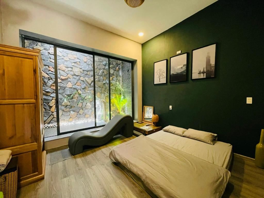 ein Schlafzimmer mit einem Bett und einem großen Fenster in der Unterkunft The Grandparents Homestay in Quy Nhon