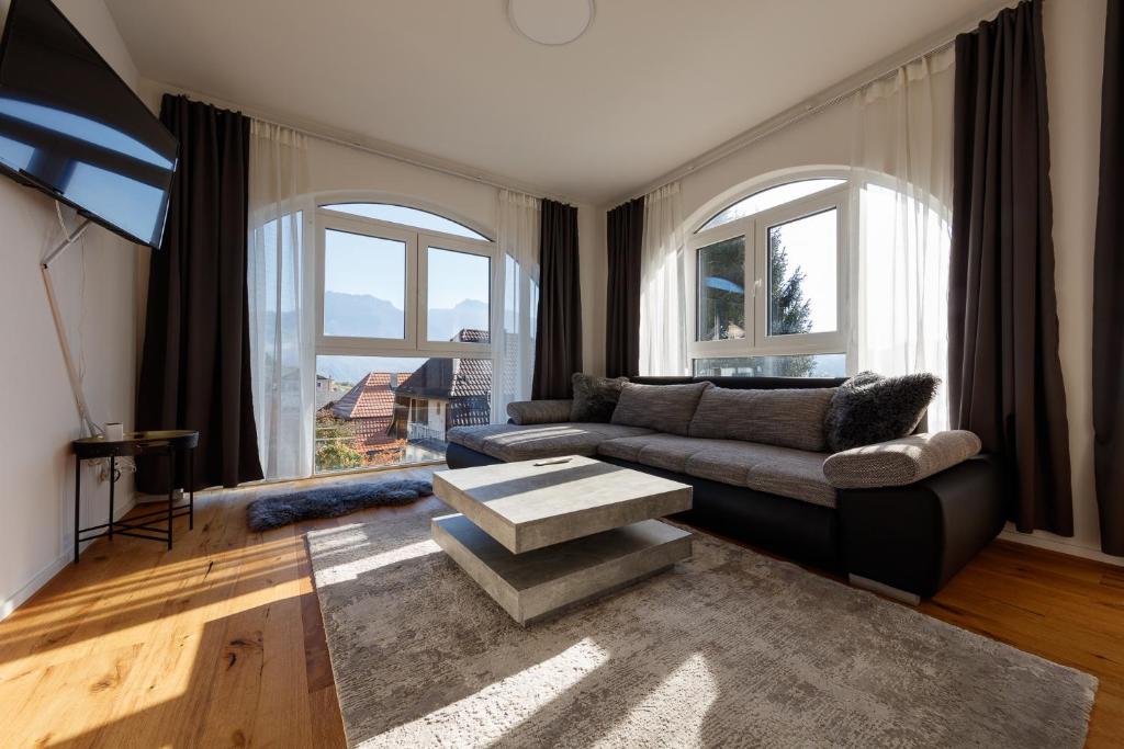 ein Wohnzimmer mit einem Sofa und einem Tisch in der Unterkunft Welcome Apartments Spiez in Spiez