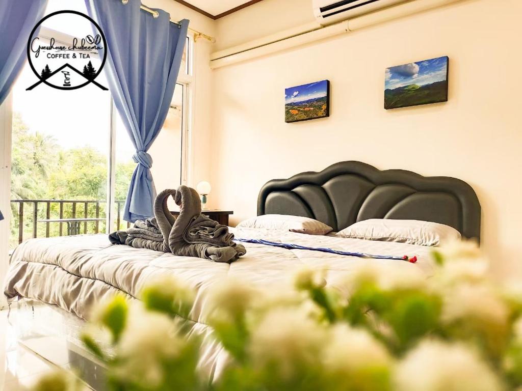a bedroom with two beds and a window at เกสต์เฮาส์ชูบีมา Guesthouse Chubeema Coffee & Tea in Ban Mai Ngae