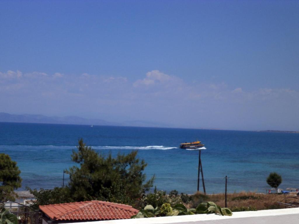 a boat in the ocean next to the ocean at Hotel Flisvos in Megalochori