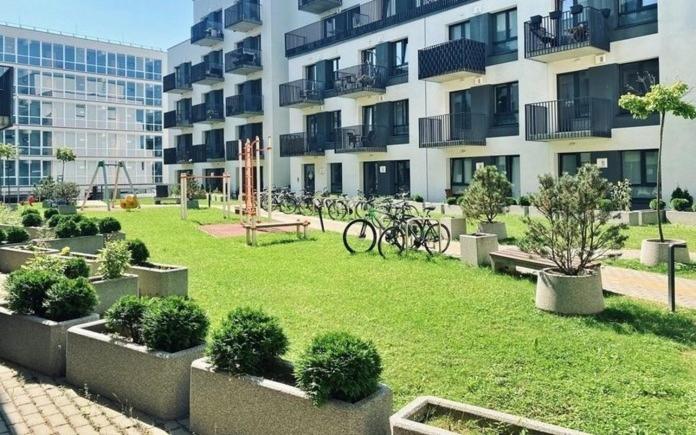 a park in front of a building with bikes in it at New Ozas flat in Vilnius