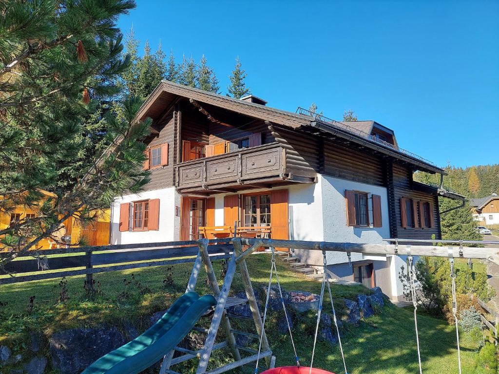 a house with a playground in front of it at Almhaus Kärnten Flattnitz in Flattnitz