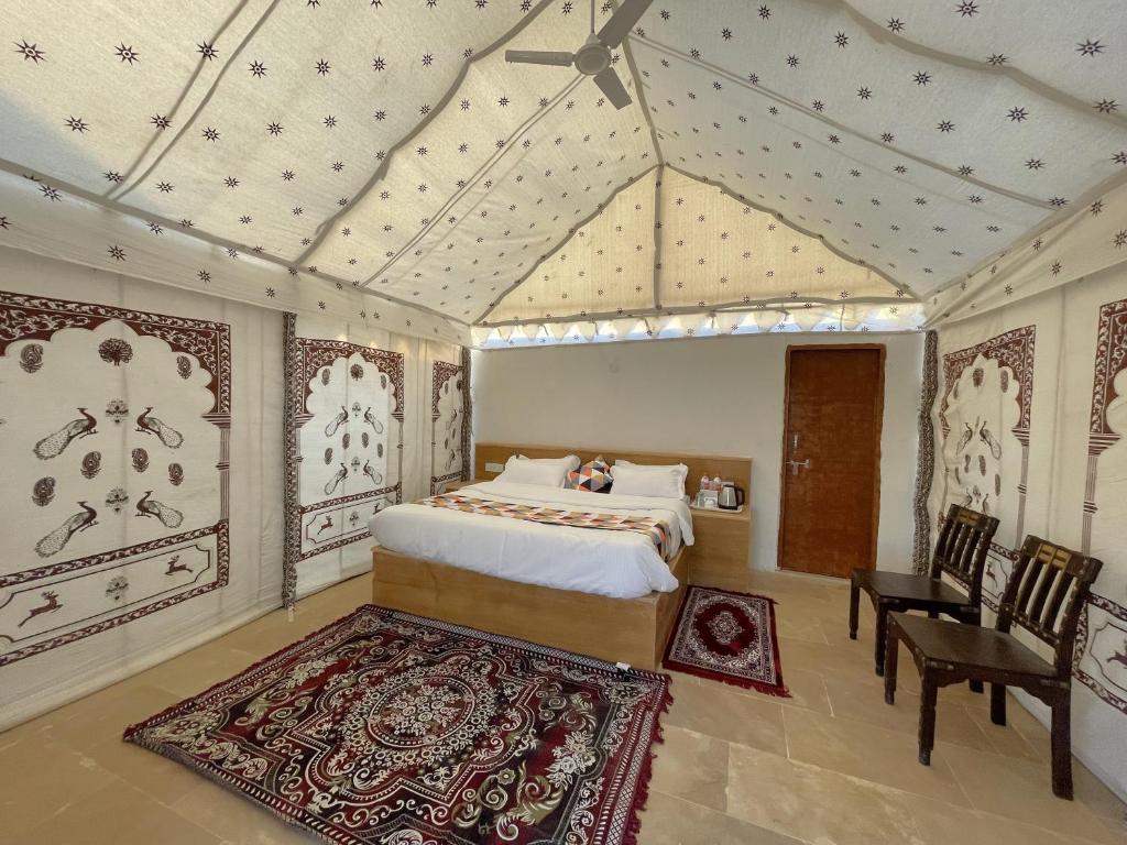 a bedroom with a bed and a table and chairs at Raj Safari Resort in Sām