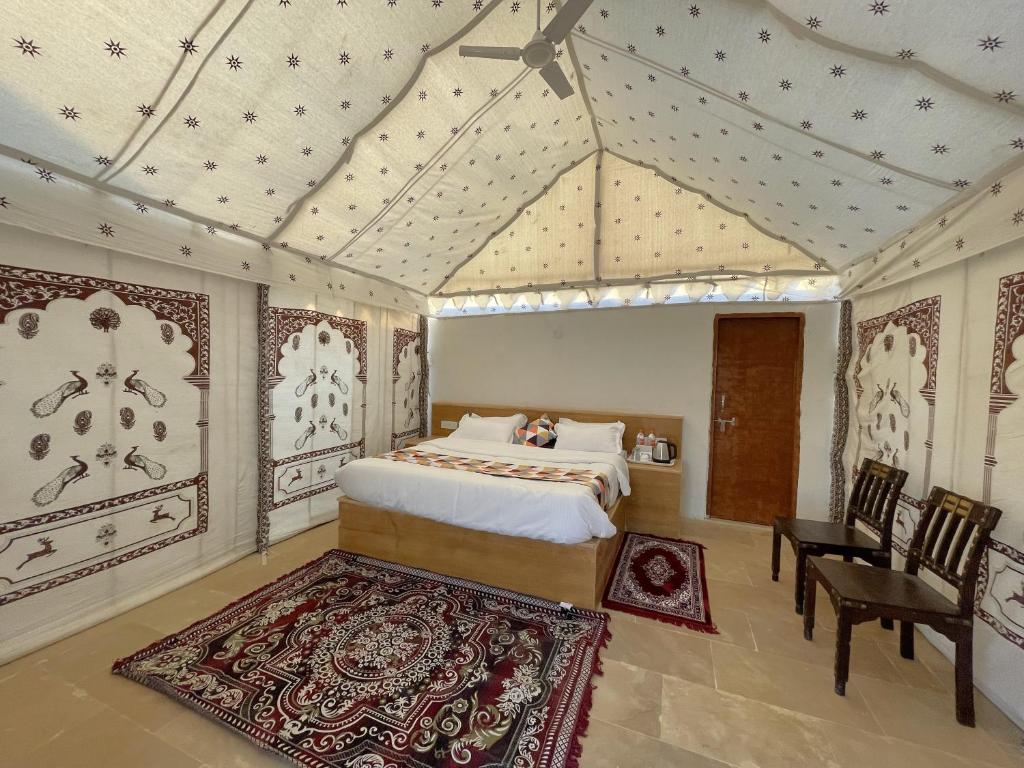 a bedroom with a bed and a table and chairs at Iceland Luxury Desert Camp in Sām