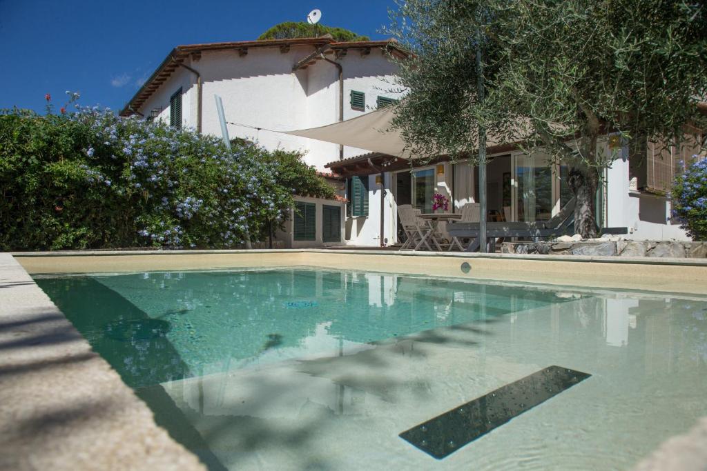 a swimming pool in front of a house at Casa degli Stecchi in Capoliveri