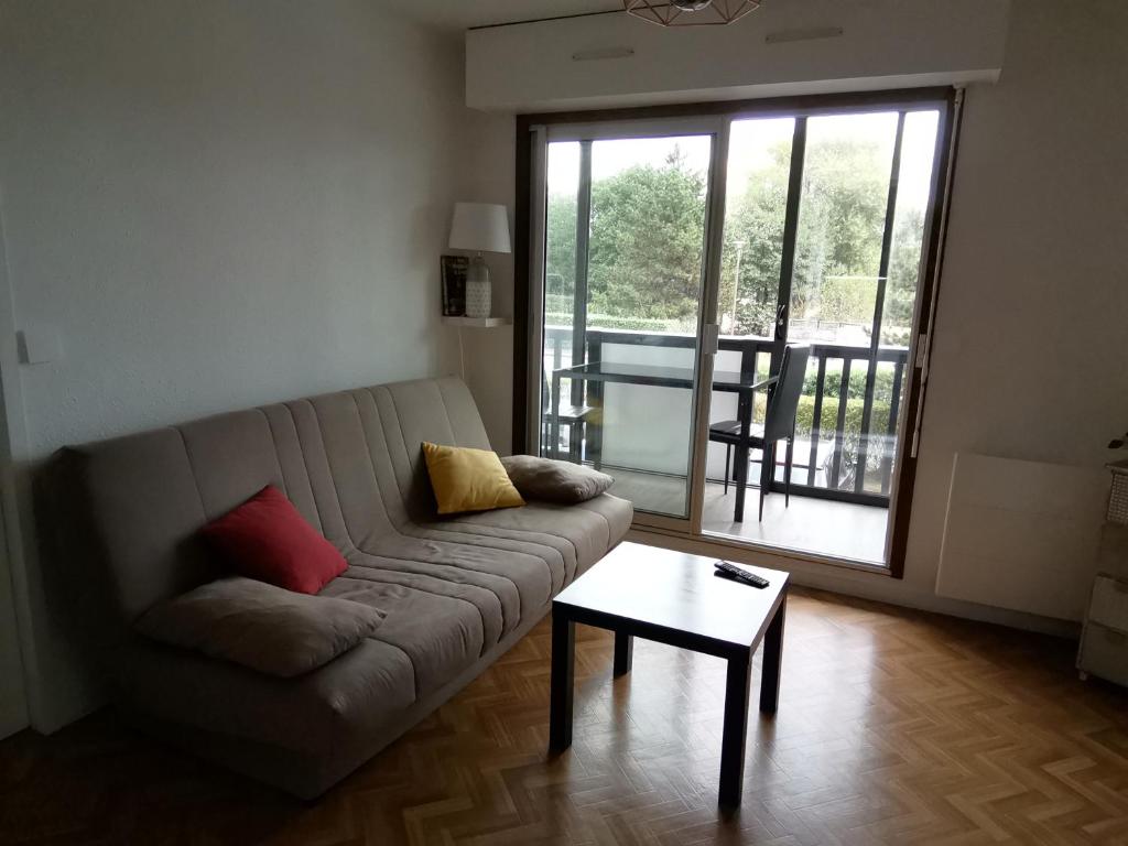 un salon avec un canapé et une table dans l'établissement Bel Appartement face au paleospace, à Villers-sur-Mer