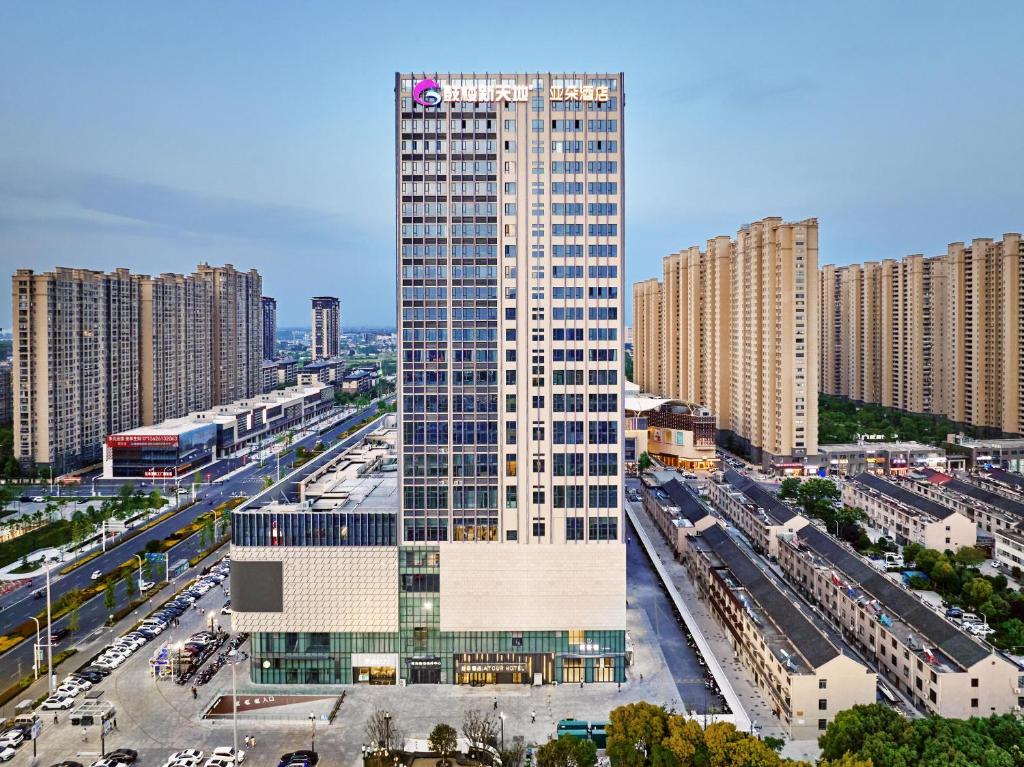un edificio alto en medio de una ciudad en Atour Hotel Taixing Municipal Government Drum Tower Xintiandi, en Taizhou