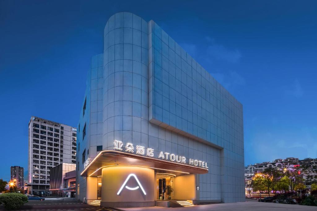 Atour Hotel Nantong Jinsha في نانتونغ: مبنى زجاجي كبير عليه لافته