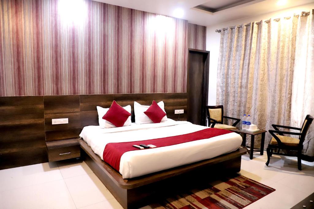 1 dormitorio con 1 cama grande con almohadas rojas en Hotel Hollywood Heights, en Amritsar