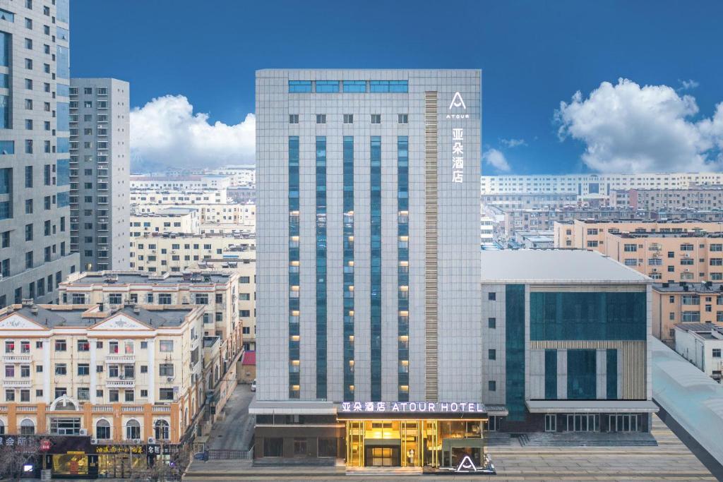 a large tall building in a city with buildings at Atour Hotel Bohai International Plaza Binzhou in Binzhou