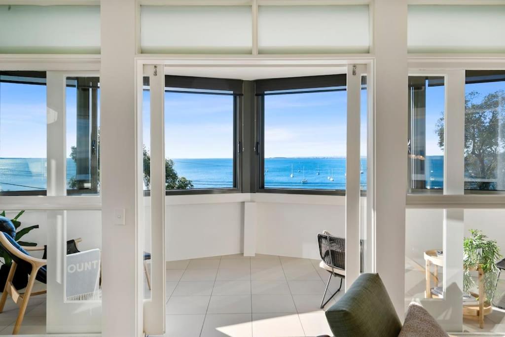 a living room with a view of the ocean at Iconic Mid-century modern, waterfront apartment in Geelong