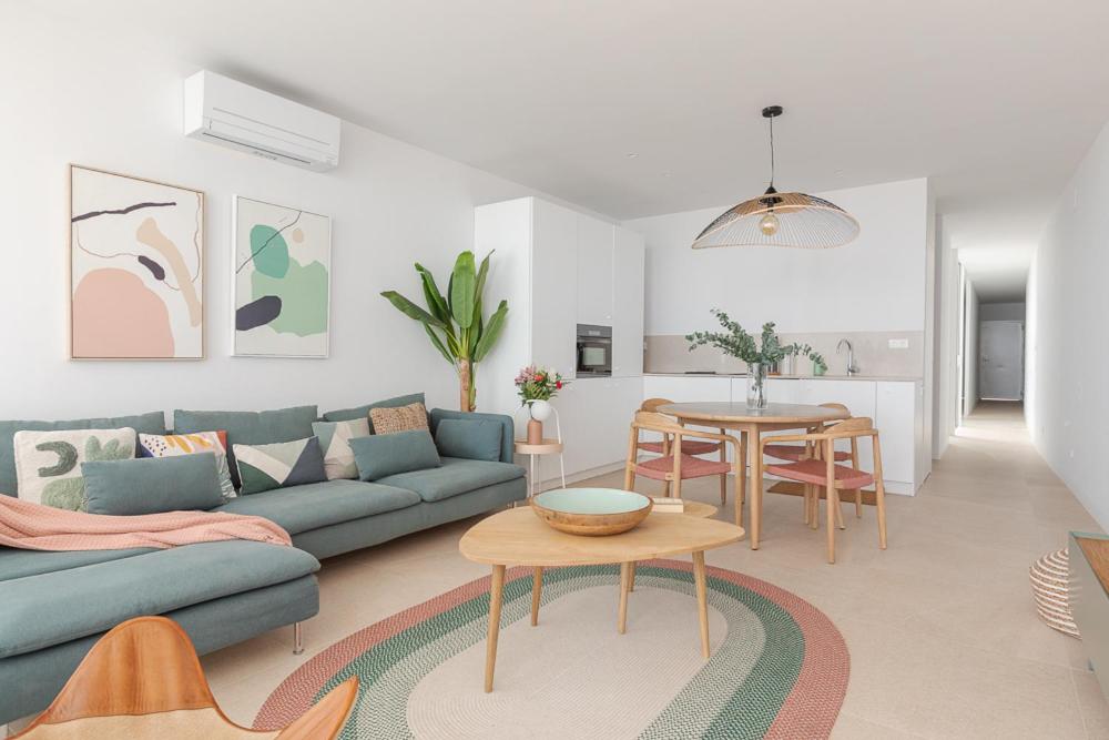 ein Wohnzimmer mit einem blauen Sofa und einem Tisch in der Unterkunft Marsalada - Ground floor front line beach apartment in Playa de Mar