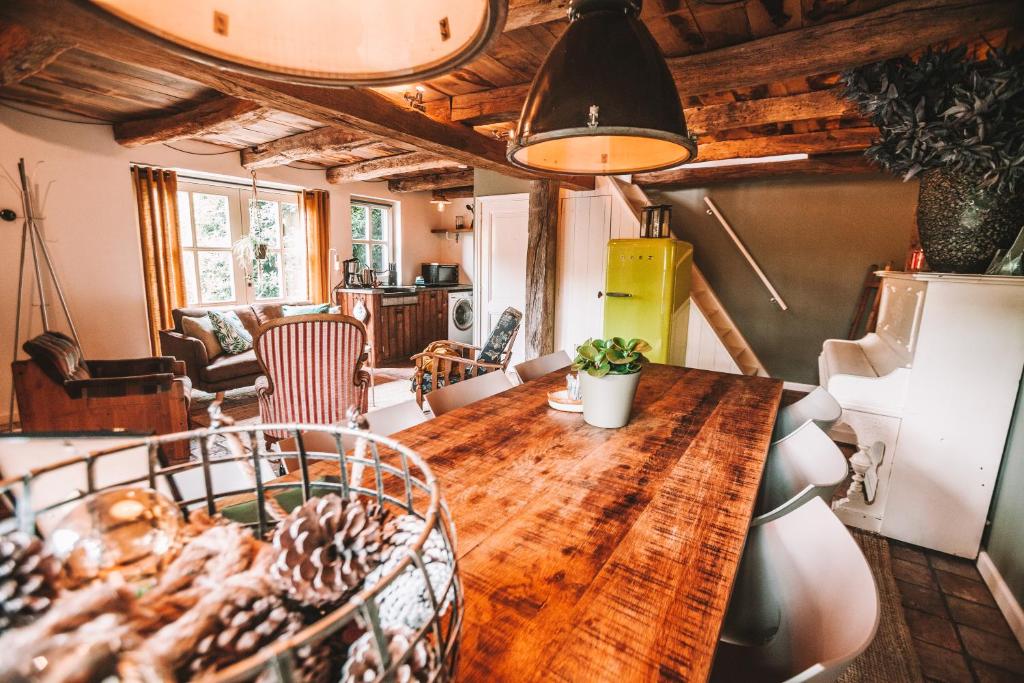 uma sala de jantar com uma mesa de madeira e cadeiras em CRASH'NSTAY - 't Silo Huis em Sprang-Capelle