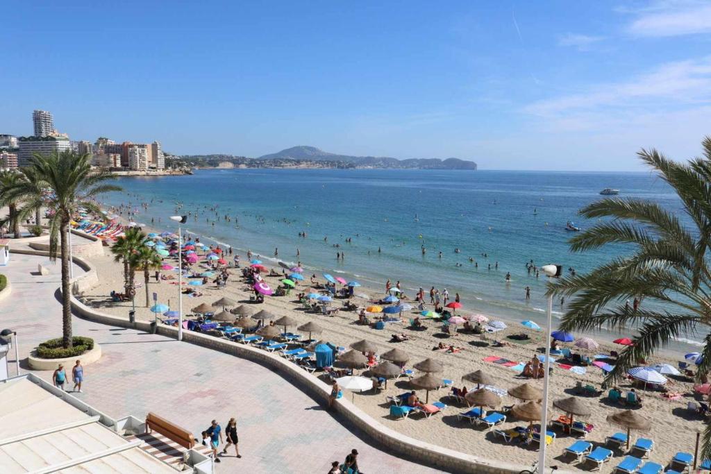 uma praia com muita gente e o oceano em INMO WEAVER 318 FM 1ª línea de playa em Calpe