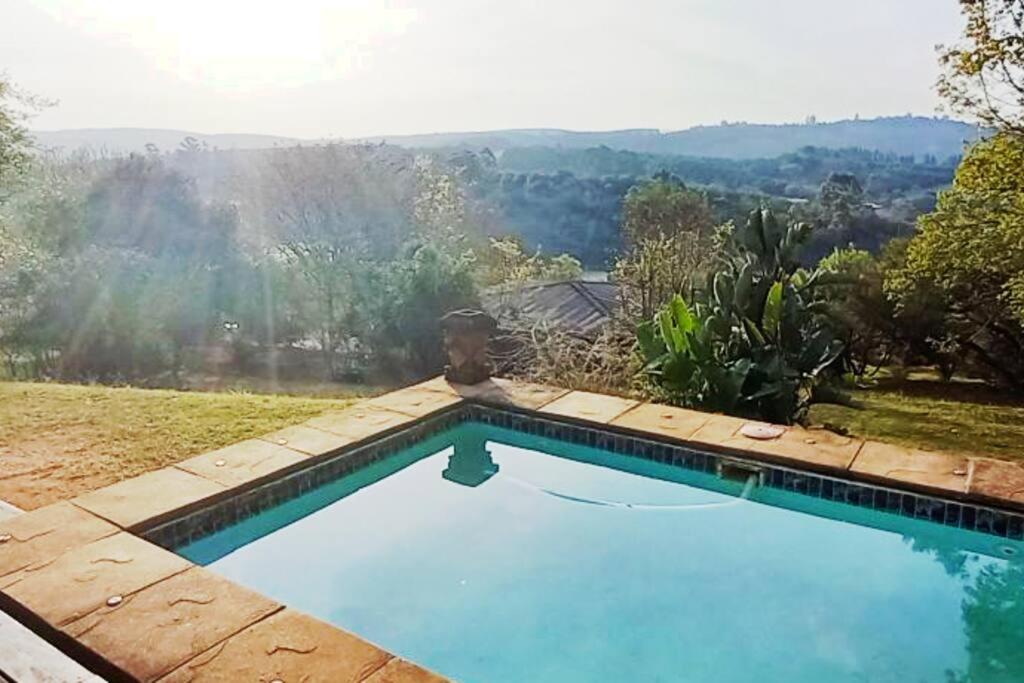a swimming pool with a view of the mountains at Bee-Eater Cottage, DaGama Dam in White River