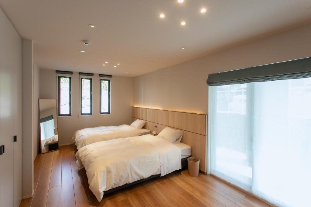 佐世保的住宿－VILLA Sasebo Stad #SS1，一间卧室设有两张床和大窗户