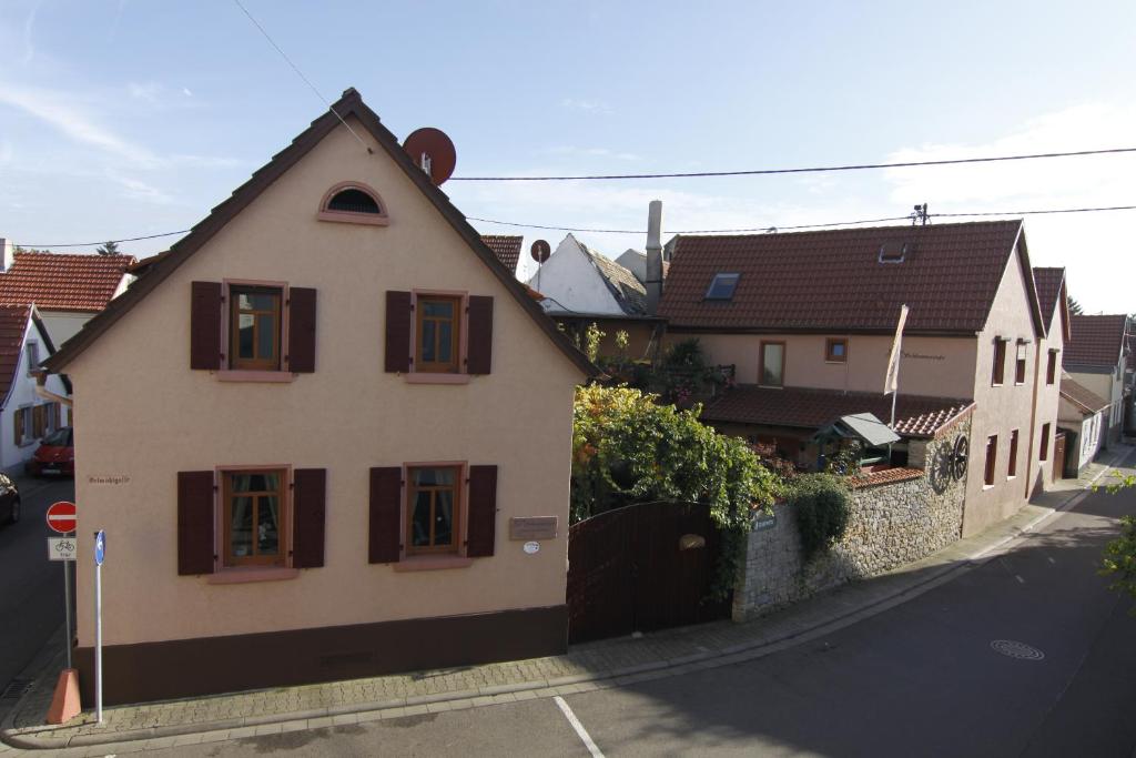 a white house with brown windows on a street at Pension Zur Schlummerstube in Guntersblum