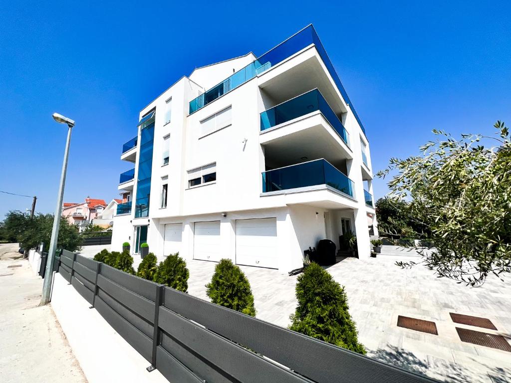 un edificio blanco con balcones azules en una calle en The Place Apartments en Srima