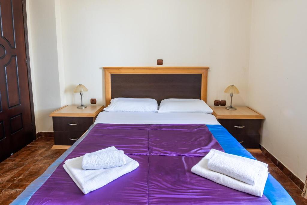 a bedroom with a large bed with purple sheets at Oceanviewvilla in Karpathos
