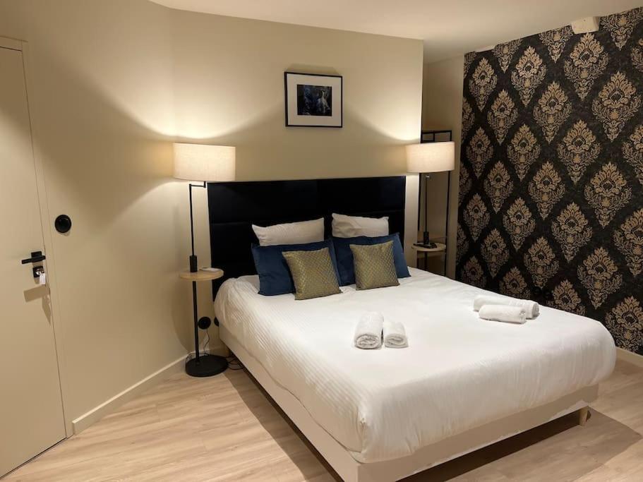 - une chambre dotée d'un grand lit avec deux chaussures dans l'établissement Bordeaux: Le Joyau de Cerf Volant, à Bordeaux