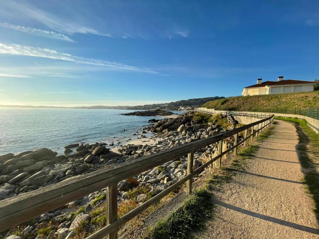 a path next to the ocean next to a house at Casa Evita in Sanxenxo