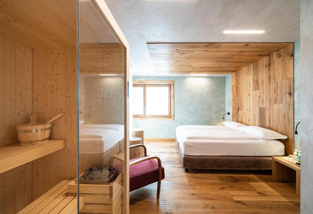 a bedroom with two beds and a walk in shower at Hotel Larice in Livigno