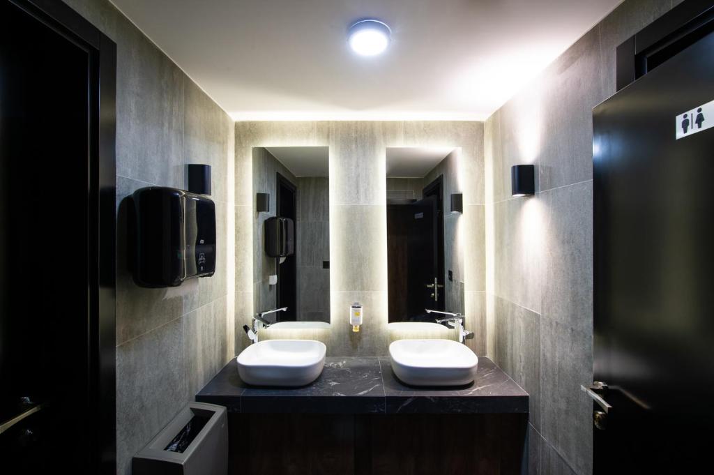 a bathroom with two white sinks on a counter at Amsterdam Hotel in Belgrade