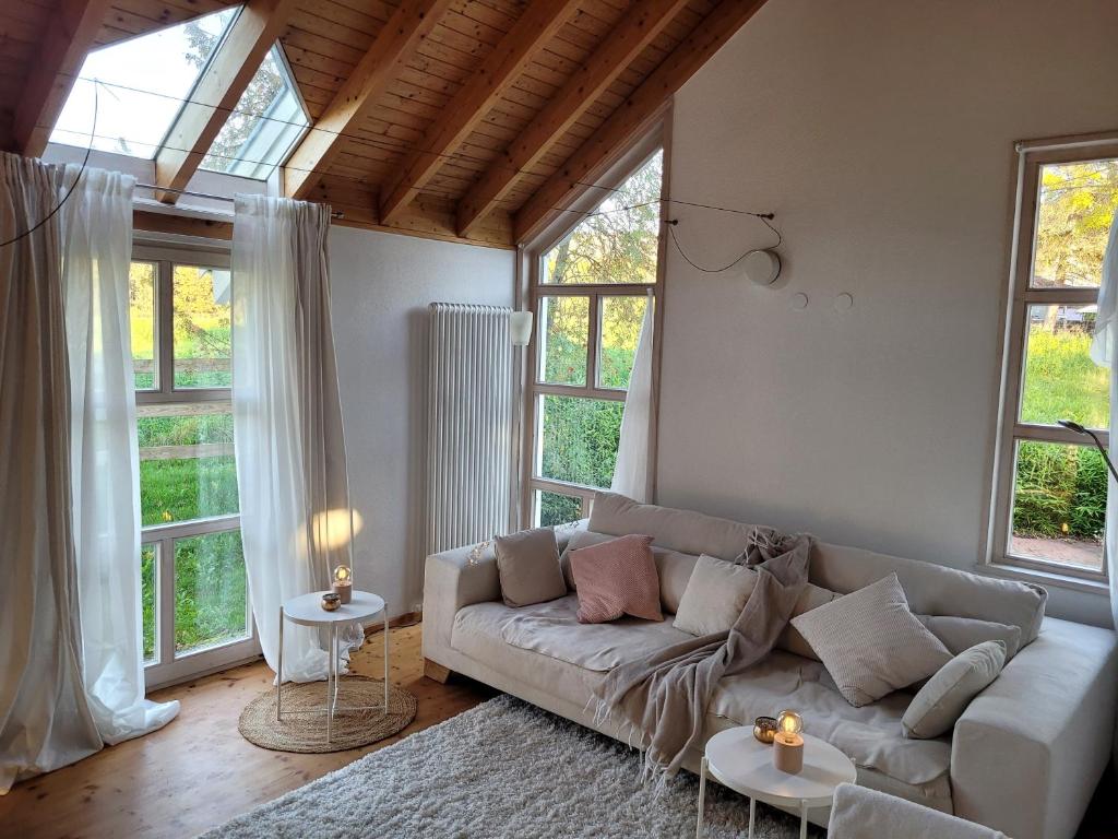 a living room with a couch and some windows at Architektenhaus Albblick in Balingen