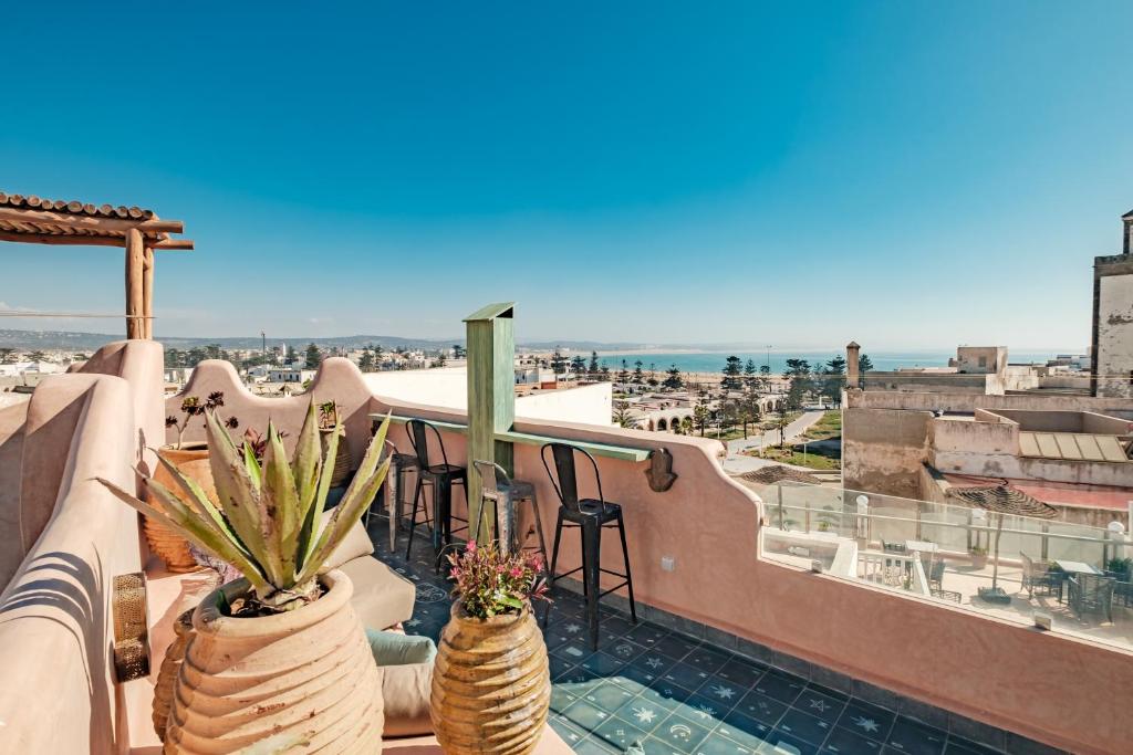 uma varanda com dois vasos de plantas num telhado em MAMA LOVA Essaouira em Essaouira