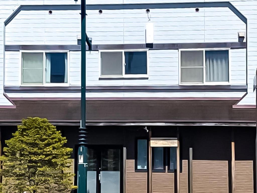 un edificio con una luz de la calle delante de él en Relak Guest House Noboribetsu Station, en Noboribetsu