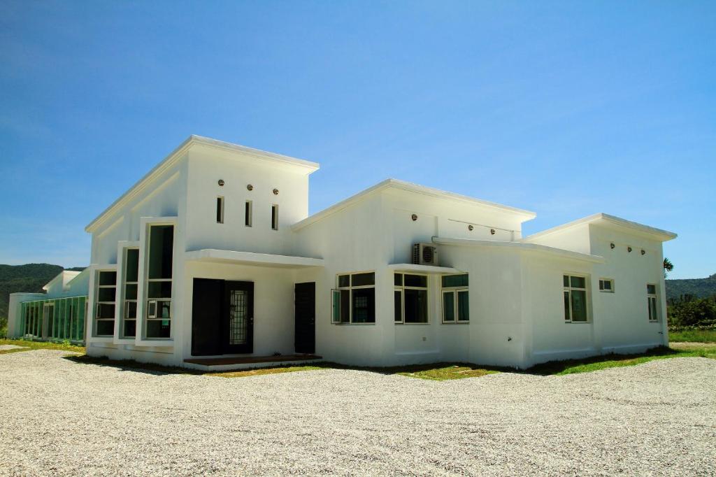 Cette grande maison blanche possède de nombreuses fenêtres. dans l'établissement Meet Canaan, à Xikou