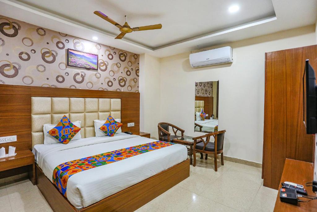 una camera con letto, scrivania e TV di FabHotel Frolic a Haridwār