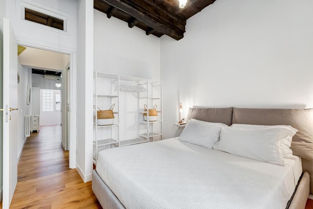 a white bedroom with a large bed and a hallway at Boschetto 118 in Rome