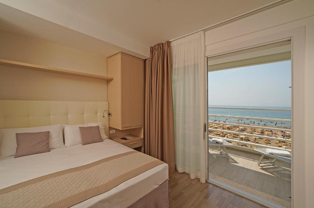 a bedroom with a bed and a view of the ocean at Hotel Strand a frontemare in Lido di Jesolo