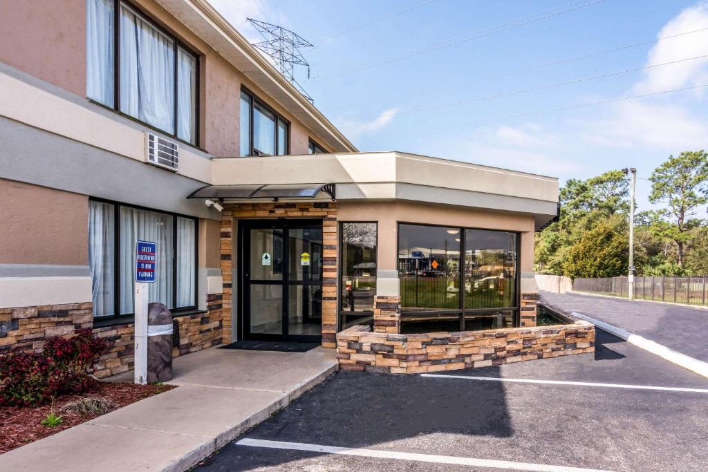 a building with glass doors in a parking lot at Quality Inn in Pensacola