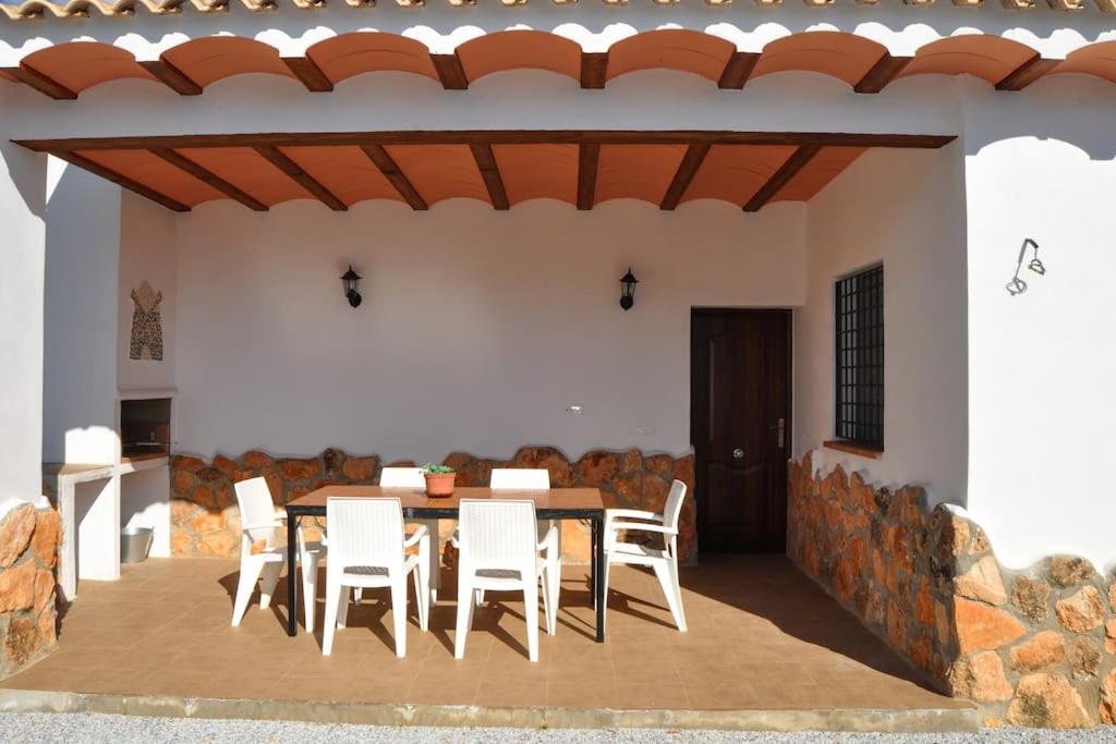 un patio con mesa y sillas blancas en Casa rural Molino S CAZORLA PISCINA COMPARTIDA, en Pozo Alcón