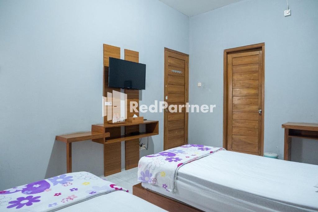 Postel nebo postele na pokoji v ubytování Omah Capung near Malioboro Area Mitra RedDoorz