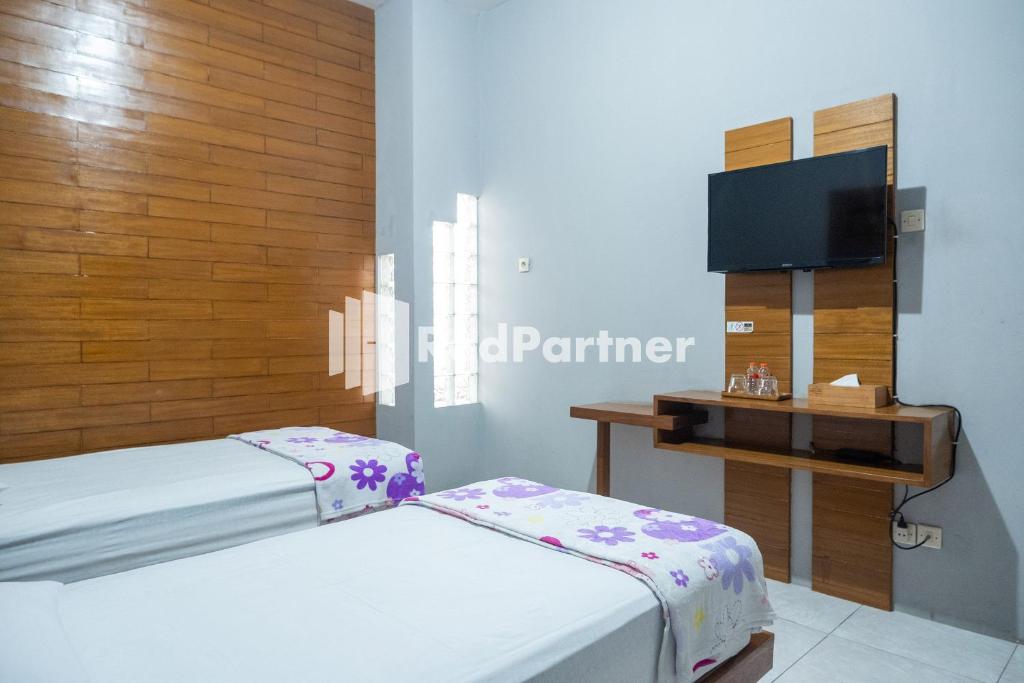 Postel nebo postele na pokoji v ubytování Omah Capung near Malioboro Area Mitra RedDoorz