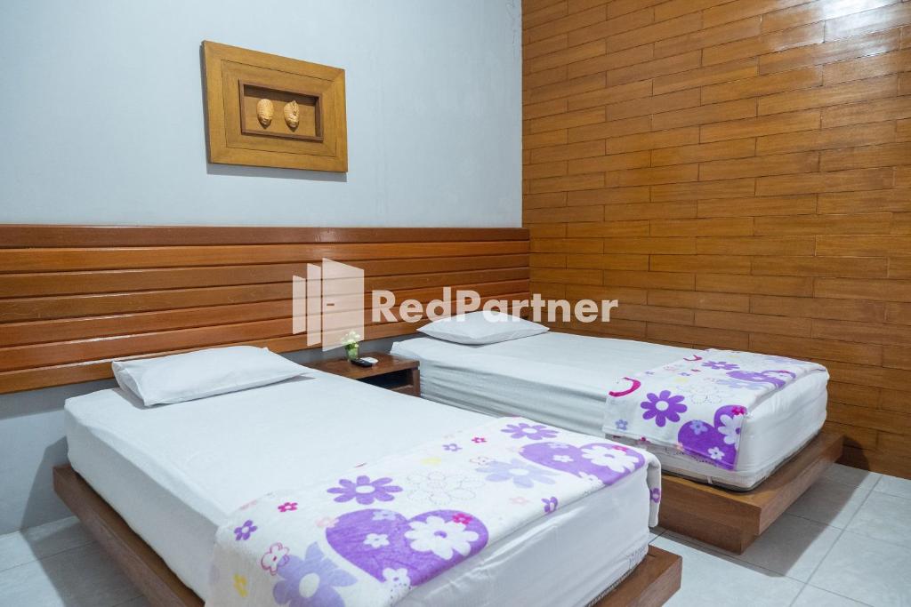 Postel nebo postele na pokoji v ubytování Omah Capung near Malioboro Area Mitra RedDoorz