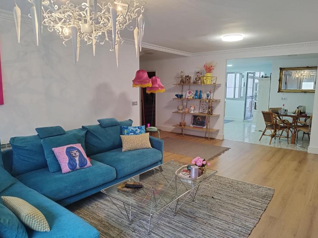 ein Wohnzimmer mit einem blauen Sofa und einem Tisch in der Unterkunft Céntrico y amplio piso con plaza parking in Cangas