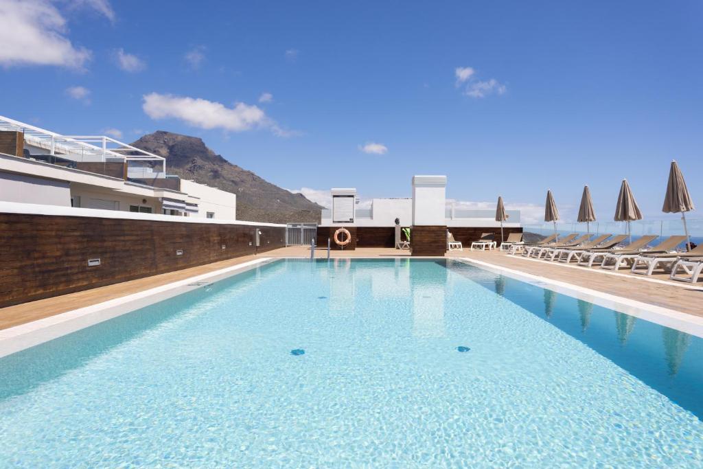 a large pool with blue water in a building at River Suite El Galeón in Adeje